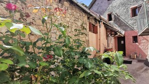 Un rústico edificio de piedra con puerta de madera y un ventanal pequeño.