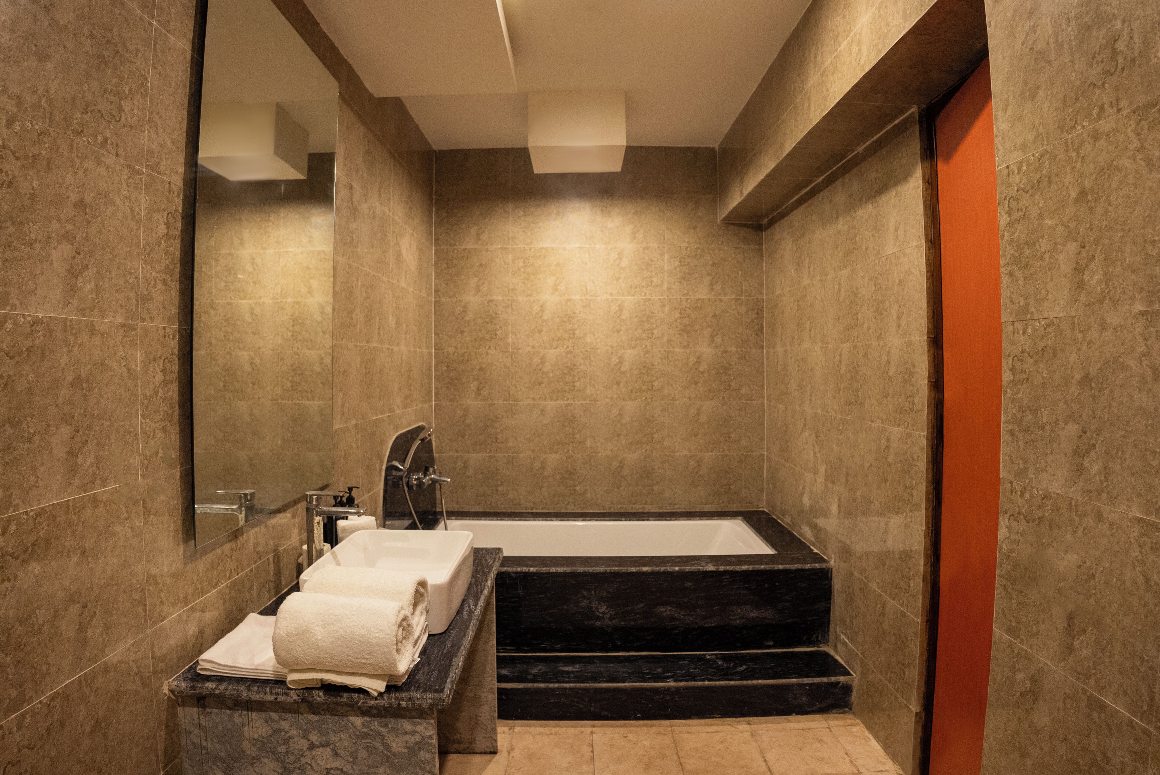 Ein modernes Badezimmer mit Badewanne, Waschbecken und Spiegel.