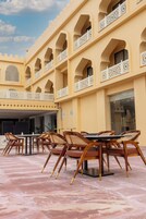 Un hotel con patio, mobiliario exterior y estilo arquitectónico tradicional.