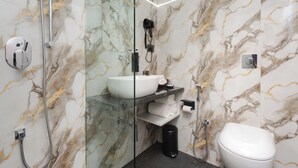 A modern bathroom with a glass-enclosed shower, a white sink, and a toilet. - Hotel Breeze Bay ex (Mumbai)