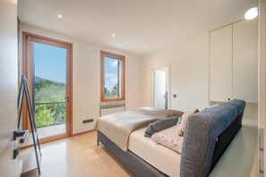 Ein Schlafzimmer mit Bett, Sofa, Balkon und einer Tür.