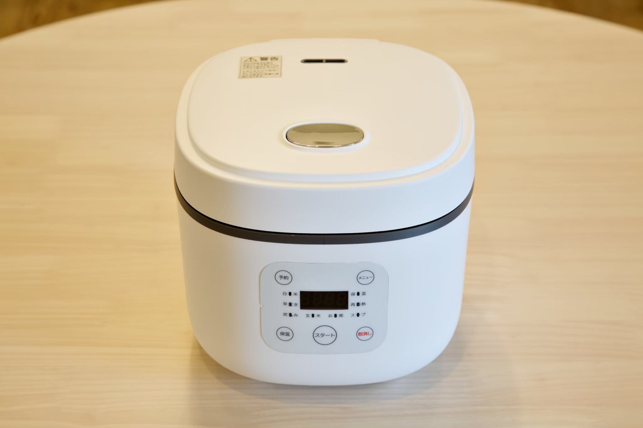Een witte rijstkoker met een digitaal display en bedieningsknoppen.