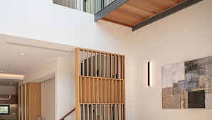 Una sala de estar moderna con un sofá modular, un sillón azul y una mesa de centro de madera.