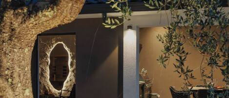 Un intérieur moderne avec un mur en pierre, un coin repas avec des chaises et une table, et une plante en pot.