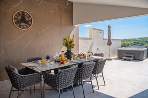Un coin repas avec une table mise pour le petit-déjeuner, des chaises, une horloge et une vue sur l’extérieur.