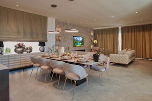 Een moderne keuken met een eethoek, een televisie en een bank in een woonkamer.