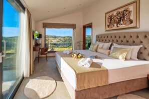 Une chambre avec un grand lit, un bureau, une chaise et un téléviseur.