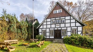 A traditional half-timbered building with a stone pathway leading to the entrance. - Holiday Home 'Hueseken' with Shared Garden and Wi-Fi (Finnentrop)