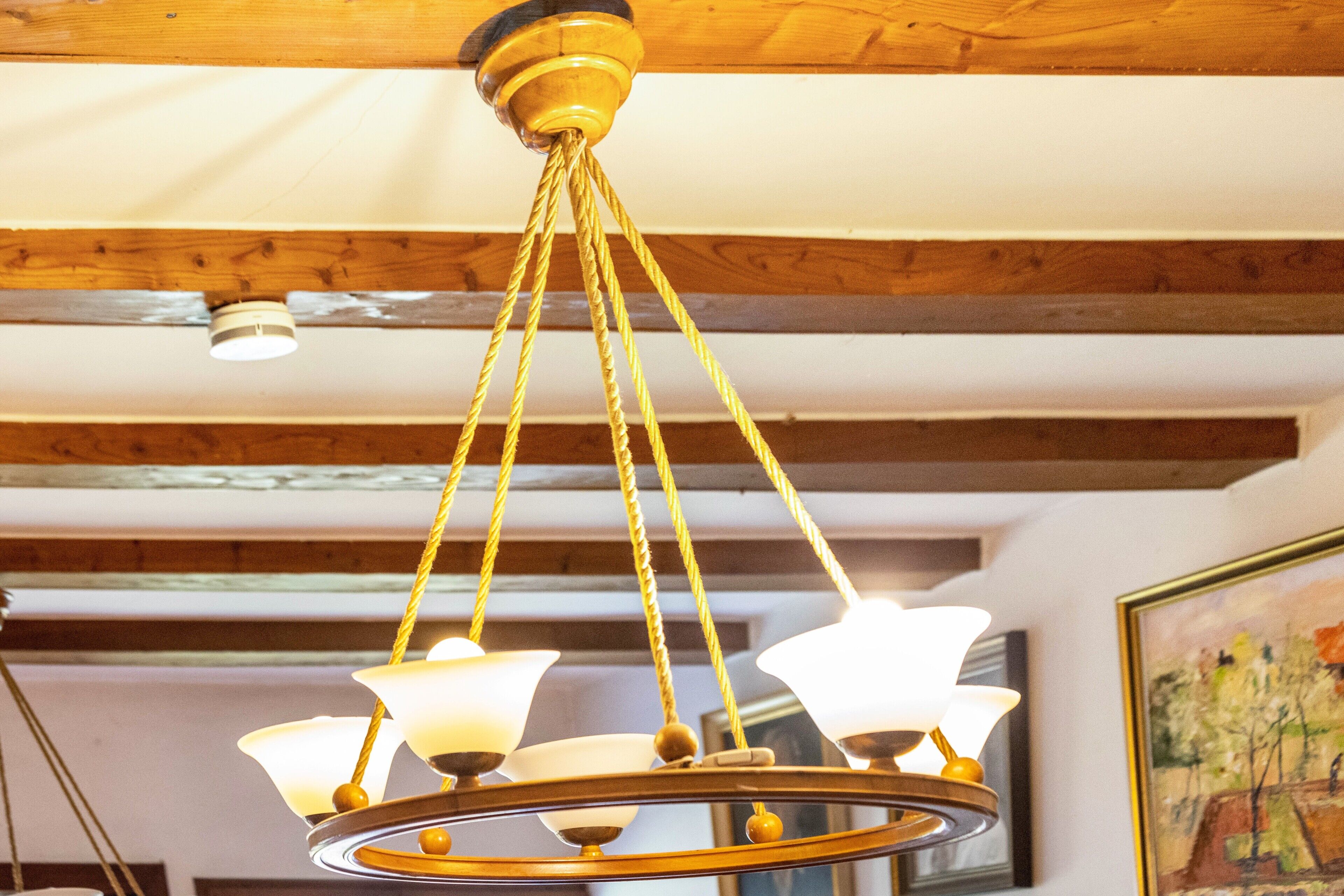 A chandelier with multiple light fixtures suspended from a wooden ceiling.