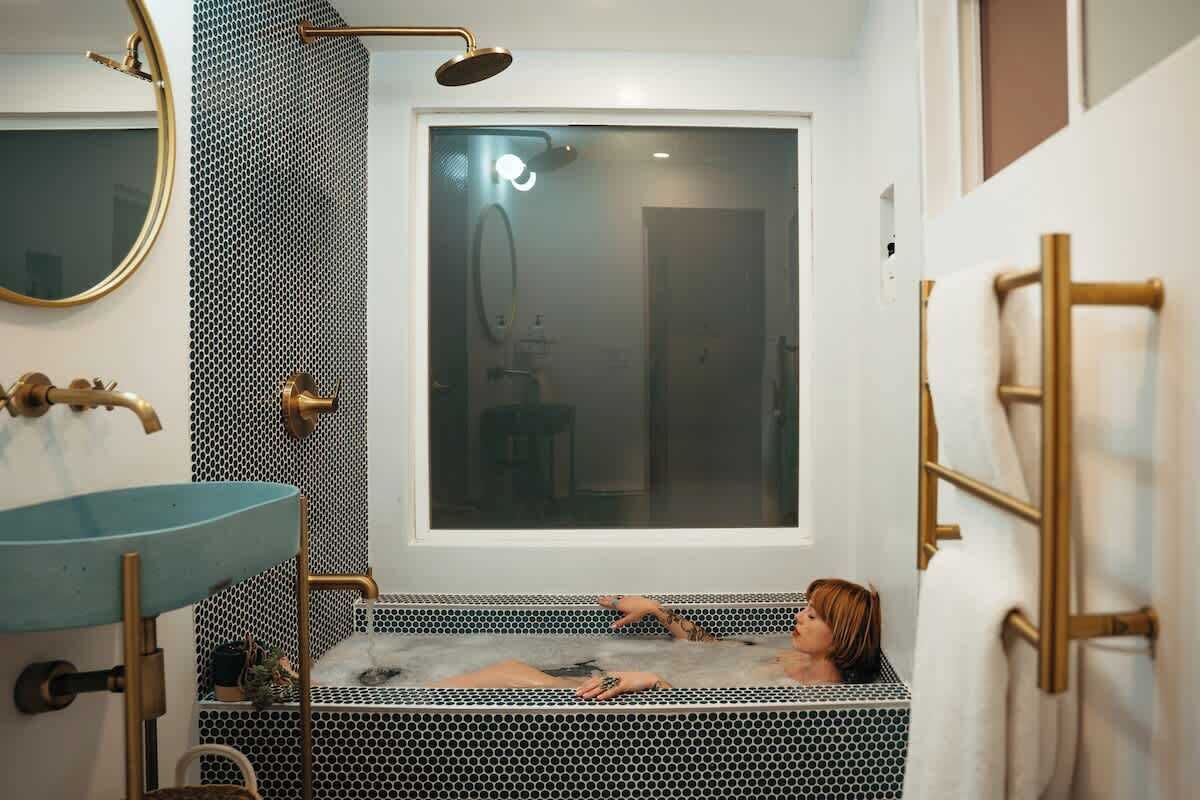 A bathroom with a bathtub, a sink, and a large window.
