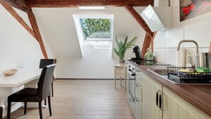 Una cucina con soffitto in legno, una finestra, un lavello e un fornello.