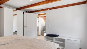 Una camera da letto con un letto, un armadio, una scrivania e una televisione.