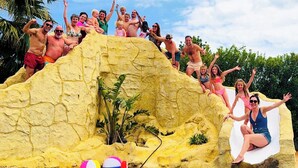 A group of people at a pool with a rock formation and inflatable toys. - Water Slide, Beer Tap, Games Room, Play Park, 2 Kitchens - Space & Fun! (VC)