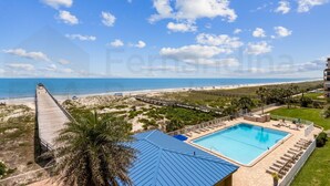 A resort with a swimming pool, beach access, and a pier.