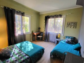 Una habitación con dos camas, un escritorio y una silla.