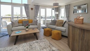 A modern living room with two sofas, a coffee table, and a wooden sideboard. - Life's a Beach (Norwich)