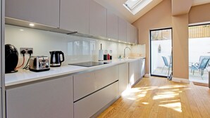 A modern kitchen with a skylight, a built-in toaster, a kettle, and a sink. - Prime Central Base! 3BR/3BA Apt w/ Courtyard. Ideal for Families and Groups. (London)