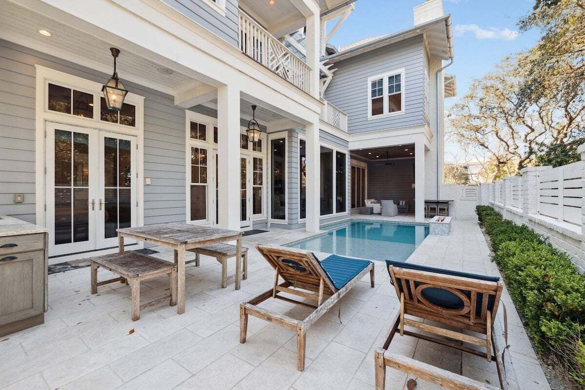 A poolside area with wooden furniture and a pool.