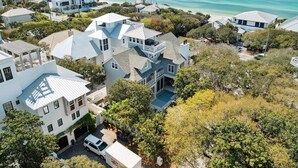 Un quartier résidentiel en bord de mer, avec des maisons modernes, une vue dégagée sur l’océan et une piscine.