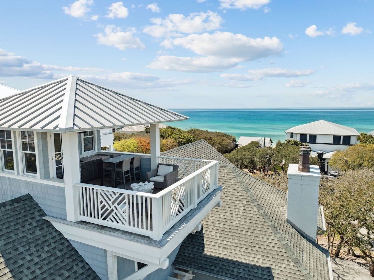 Een wit gebouw met balkon, met uitzicht op het strand.