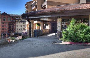 A building with a Village Center sign, stone pillars, and a barbecue grill outside.