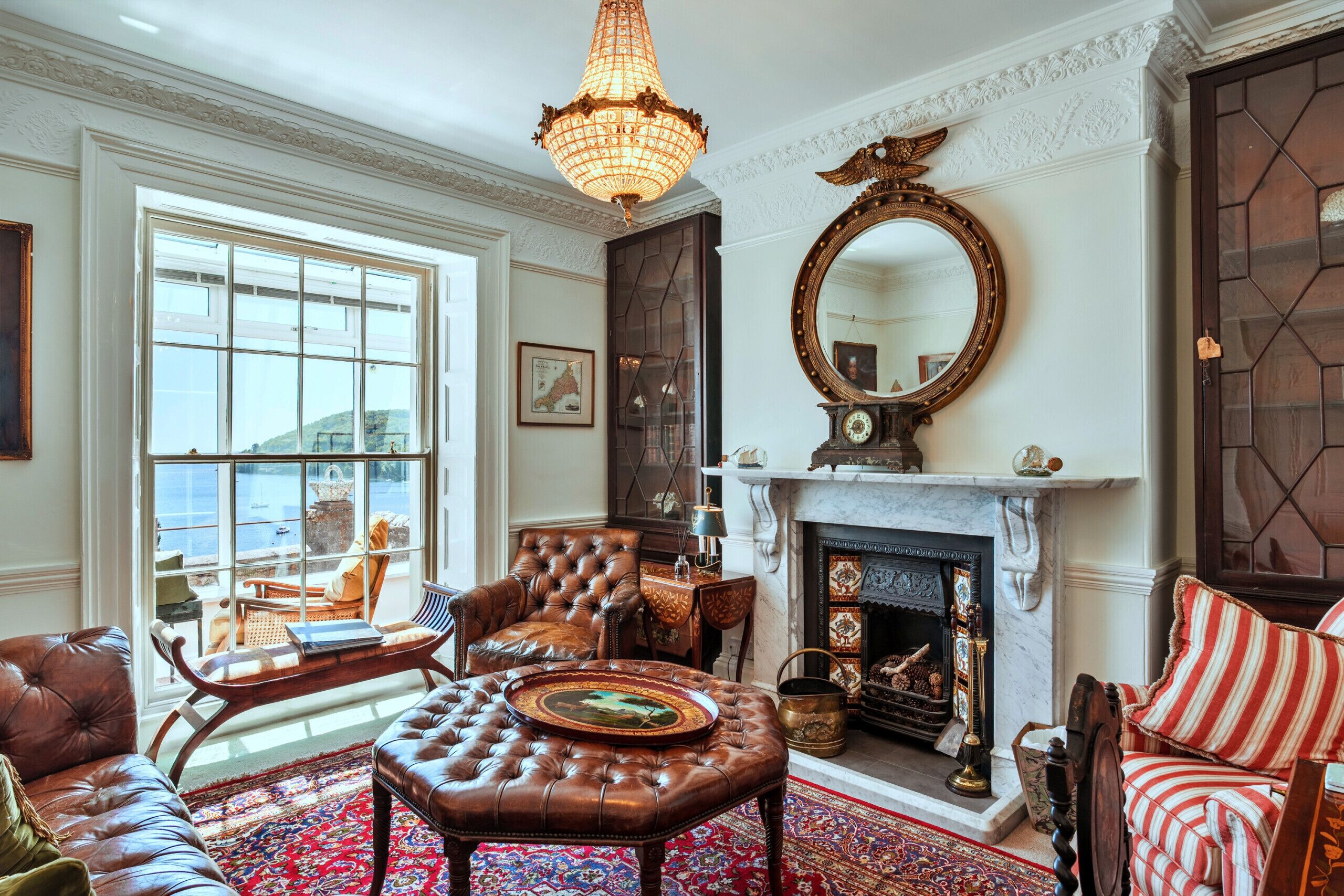 A traditional living room with leather furniture, a fireplace, and a large mirror.