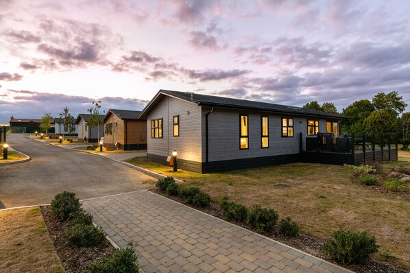 A modern building with a paved driveway and well-maintained lawn.