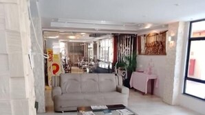 A spacious living area with a sofa, coffee table, and a view of the dining area. - Hotel Visconde  (Sobral)