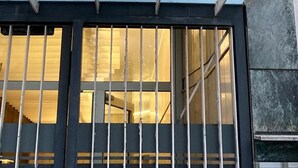 A building entrance with a large glass window and metal bars. - Aro's House (Cremona)
