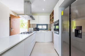 Deluxe Condo | Private kitchen | Full-sized fridge, microwave, oven, coffee/tea maker