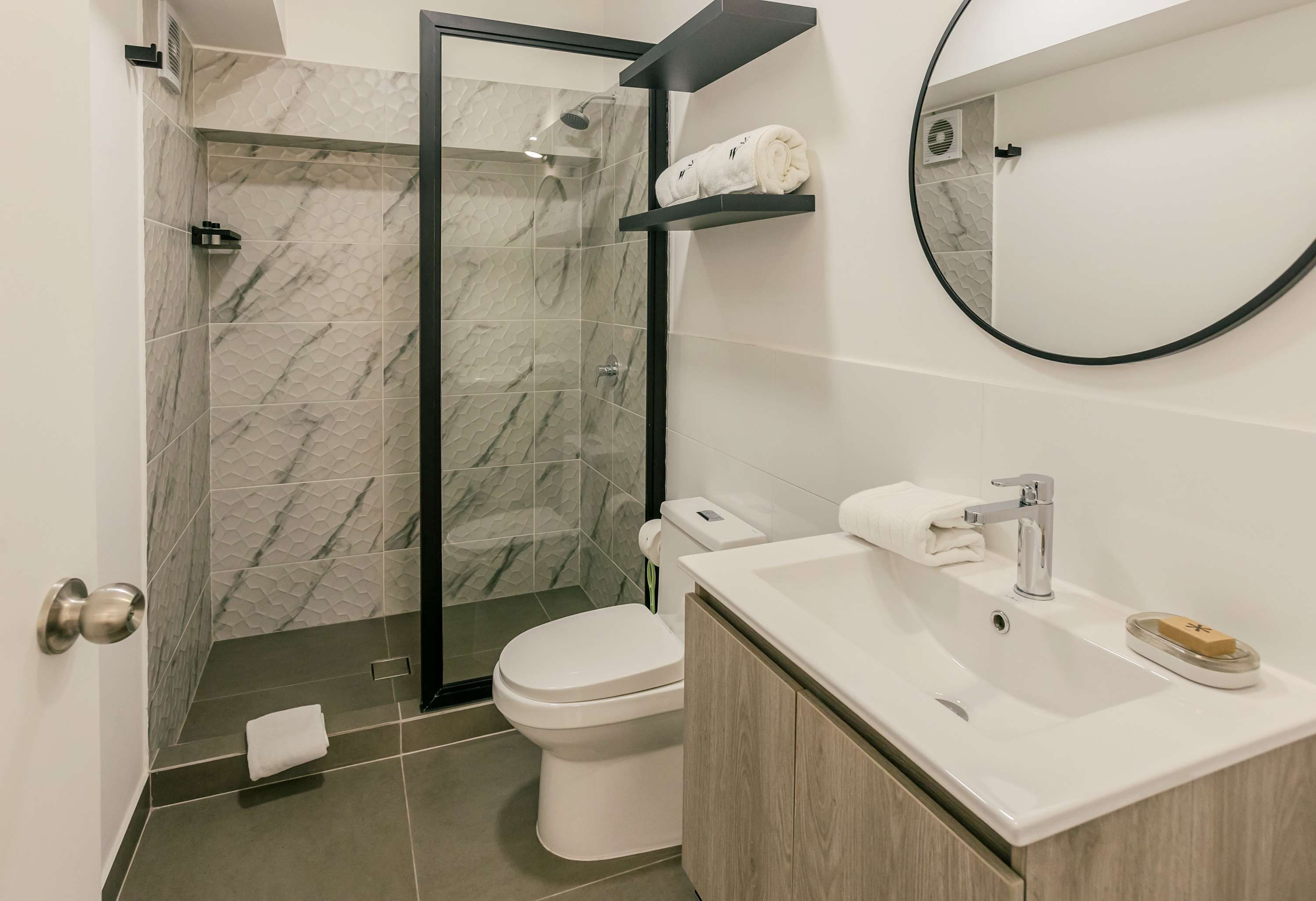 Une salle de bain moderne équipée d’une douche, de toilettes et d’un lavabo.