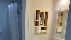 A bathroom with a shower, toilet, sink, and a mirror with a decorative frame. - Awesome II_Beach Views From the Bed (Myrtle Beach)