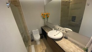 A modern bathroom with a white toilet, a round sink, and a large mirror. - Magnificent location, Rooftop with Ocean View (Playa del Carmen)