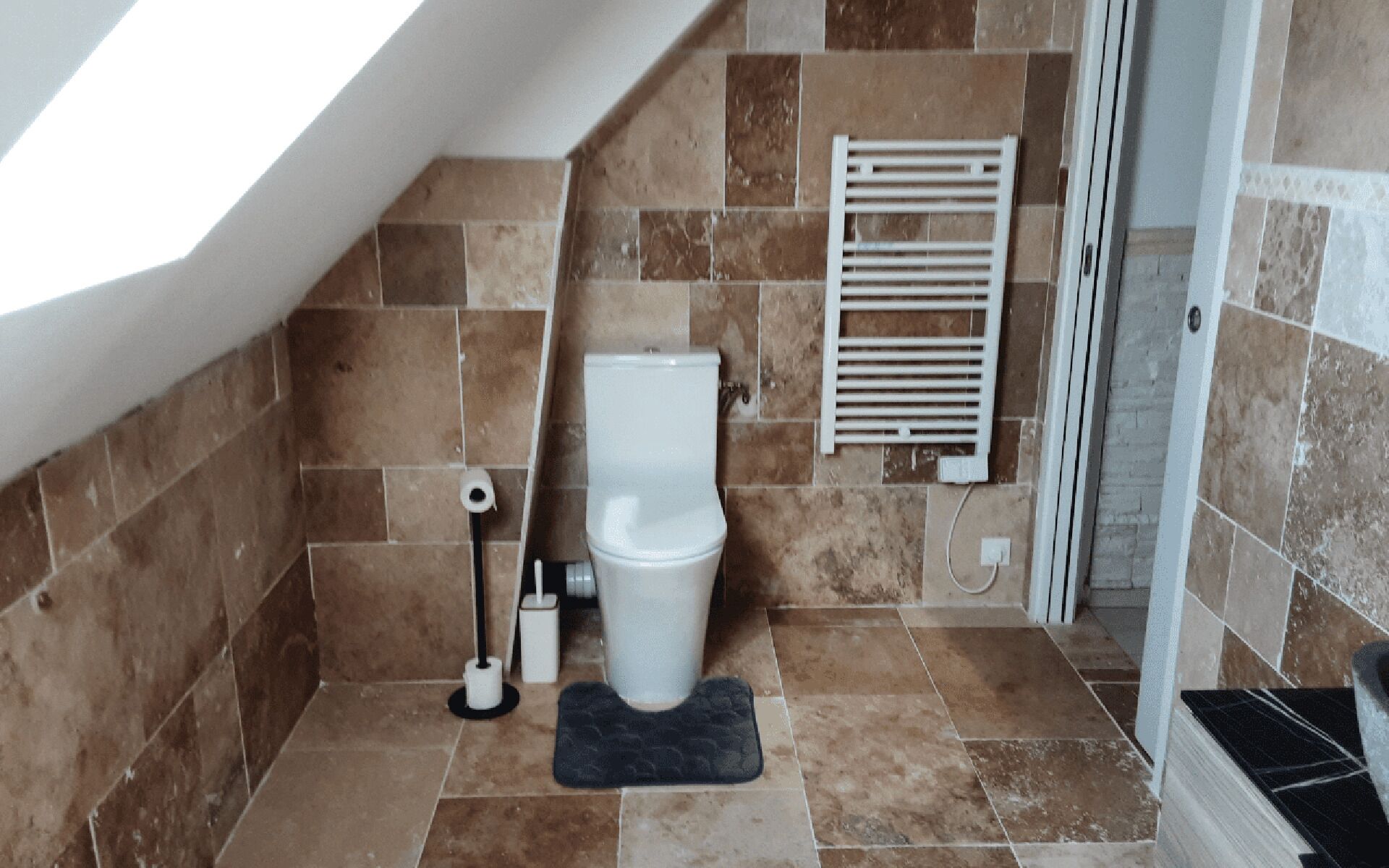 Un baño con inodoro, toallero y zona de ducha.