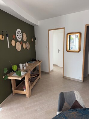 Una habitación con una mesa de madera, un espejo y varias decoraciones en las paredes.