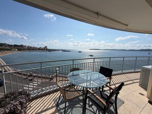 A balcony with a glass table and chairs, overlooking a coastal area with boats and a marina. - Apartment "Sur l'Eau" walking distance to beach and center. Gulf of Saint-Tropez (Sainte-Maxime)