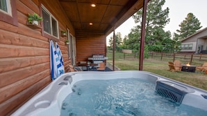 A hot tub with a wooden deck, a grill, and outdoor seating. - Modern Mountain Home w/ Hot Tub, Fenced Yard & Near Lakes (Pagosa Springs)