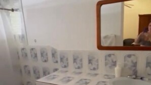 Un baño con inodoro, lavamanos y espejo.