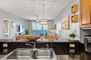 A modern kitchen with a large island, double sinks, and a view to the outside. - Breathetaking Views! New Specials! Reach out for Extended Stay Rates! (Miramar Beach)