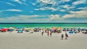A beach with tents and umbrellas, people walking, and a clear sky. - Breathetaking Views! New Specials! Reach out for Extended Stay Rates! (Miramar Beach)