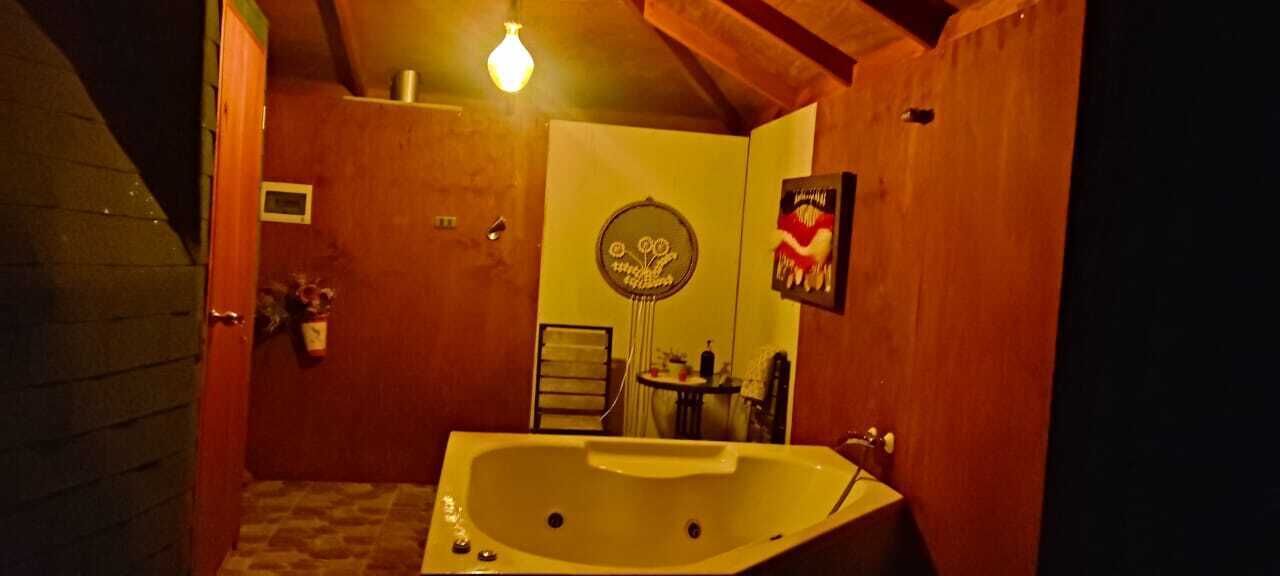A bathroom with a large bathtub, a towel rack, and a mirror.