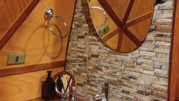 A wooden vanity with a white sink, a mirror, and a towel ring.