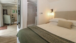 A bedroom with a bed, a chair, a wardrobe, and a bathroom.