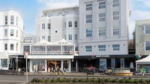 Straßenansicht mit einem Gebäude, das eine Bar namens 'VUE BAR' und einen Shop namens 'RIP CURL' zeigt.