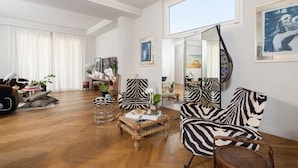 A spacious living room with a large mirror, zebra-striped chairs, and a wooden coffee table.