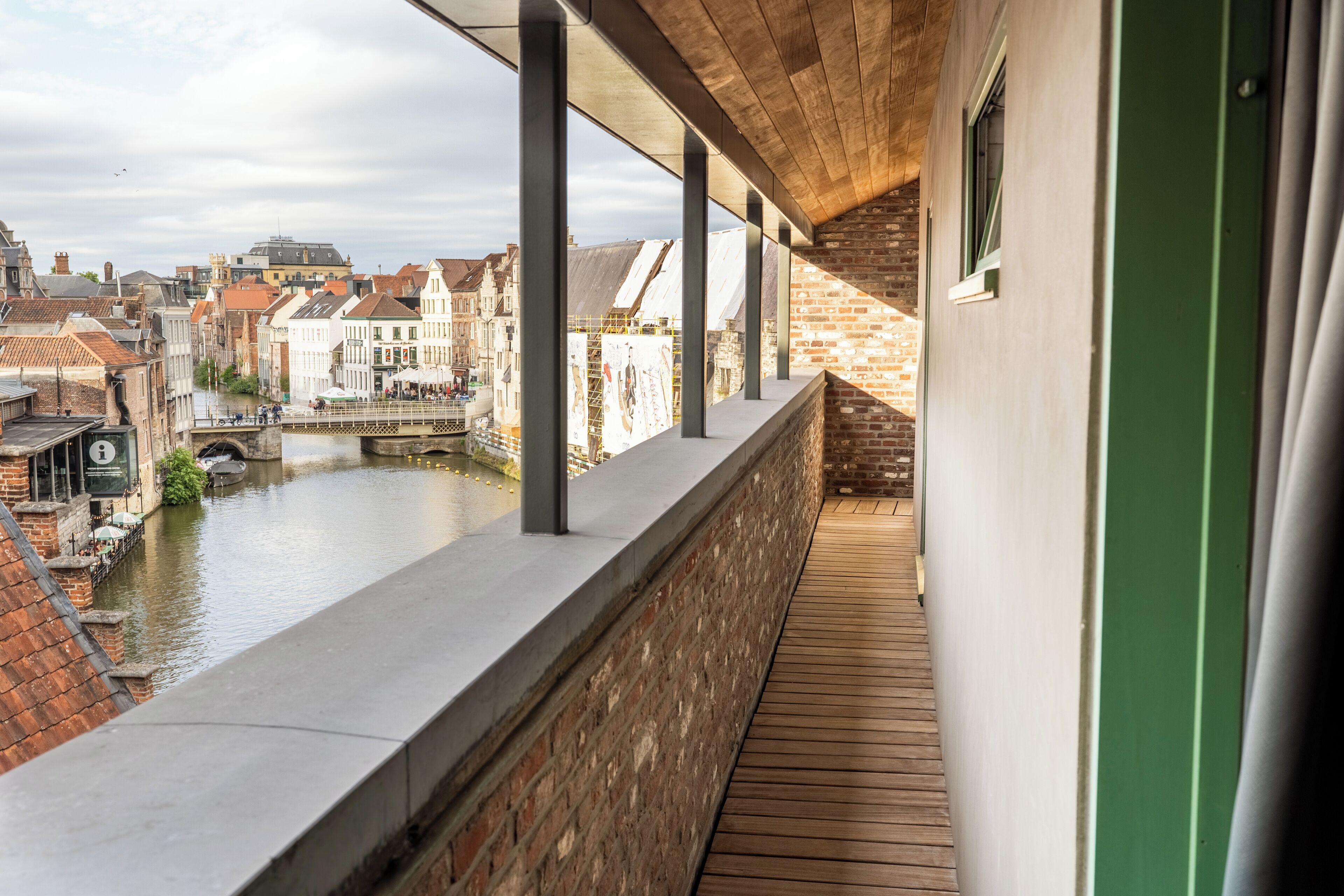 A balcony with a view of a canal and historic buildings.