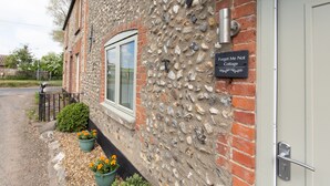 A stone building with a door labeled "Forget Me Not Cottage." - Forget Me Not Cottage (Binham)