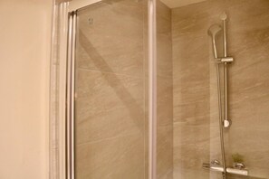 Een douche, een haardroger, handdoeken, toiletpapier