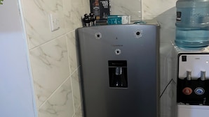 A compact kitchen with a water dispenser and a refrigerator. - Chic 1-bedroom apartment in wonderful Nairobi with AC, fitness room (Nairobi)
