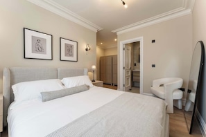 A bedroom with a large bed, a bedside table, a chair, and a wardrobe. - Host & Stay | Albion Place (Ramsgate)